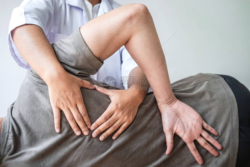 医生或物理治疗师工作检查治疗员男患者受伤的背部图片