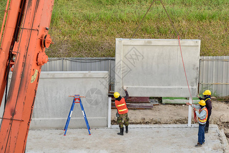 建筑工人和工程师在新建仓库工地寻找移动式起重机提升图片