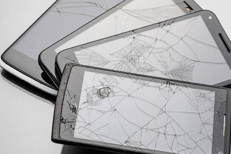 碎玻璃智能手机在灰色表面闪亮许多玻璃图片