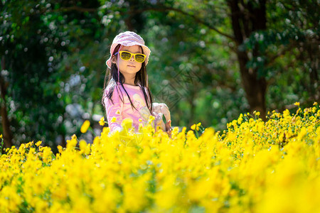 穿粉红衣服的亚洲小女孩戴着帽子和墨镜站在图片