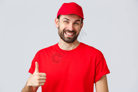 红帽子和T恤制服友好而愉快的递者鼓励在互联网上下订单图片