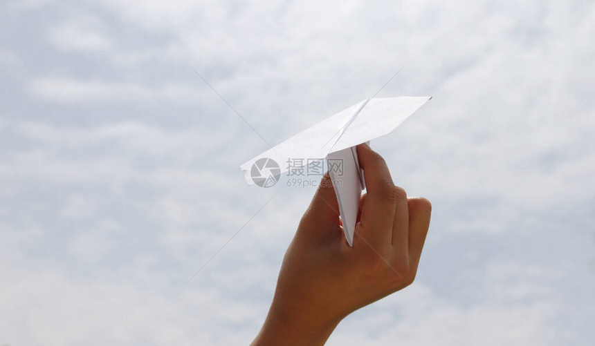 一架纸飞机用女人的手在蓝天上图片