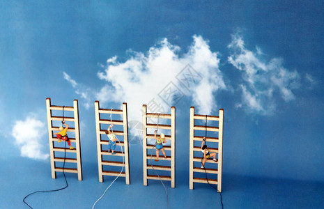 小型登山者在蓝天的背景下爬上木制梯子图片