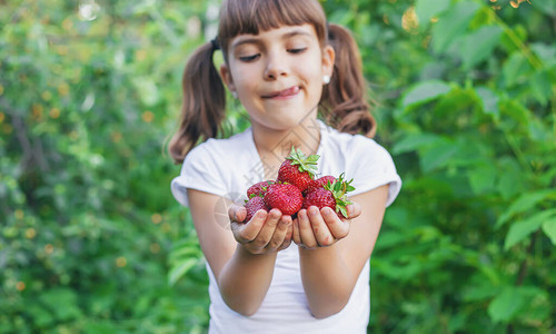 一个手拿着草莓的孩子有选择图片