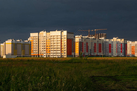 新建的房屋在落日的金色光芒映衬下乌黑的暴风雨的天空日落有起重图片