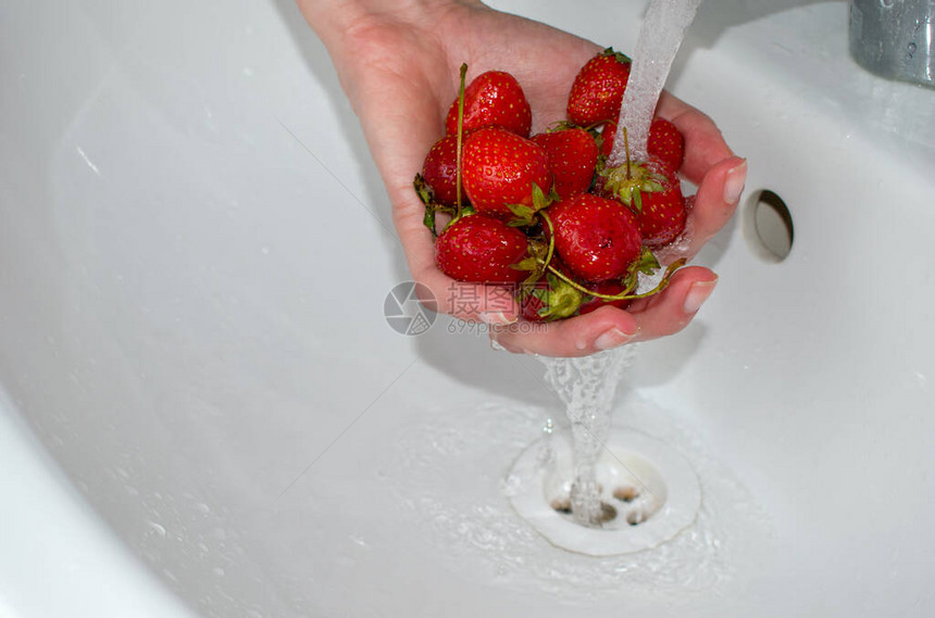 雌手洗莓子草莓在水流下准备果汁和图片