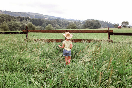 戴牛仔帽的小女孩在山间农场的西部玩耍图片