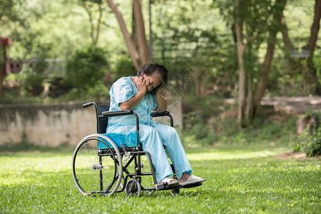 孤独的老年妇女在医院花园轮椅上坐着图片