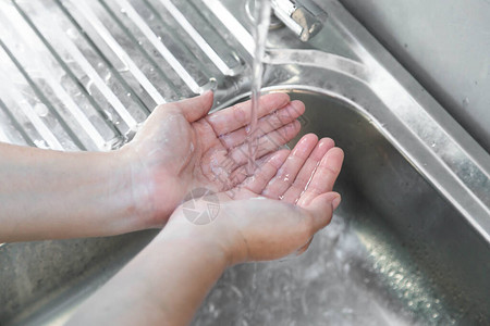 洗手人在水槽用自来水冲洗肥皂图片