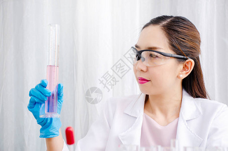 科学家美女研究并在实验室试管中滴入医用化学品样科学化学技术图片