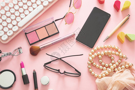 时尚博客使用笔记本和女配件的工作空间有粉色背景的女产品平图片