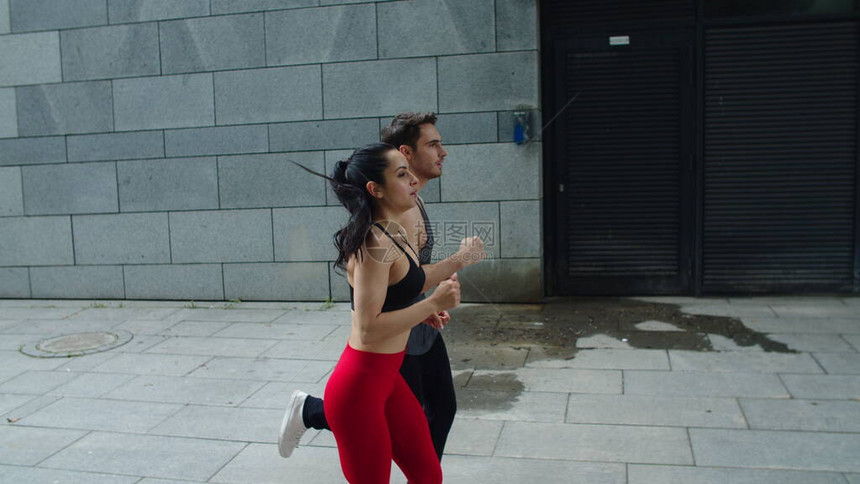 运动型夫妇在晨跑中慢跑健身男人和女人一起在有氧训练中跑步年轻夫妇训练在城市街道慢图片