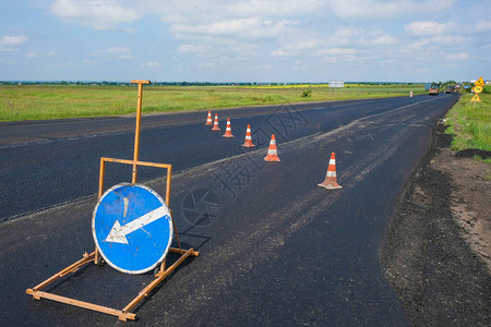乌克兰道路维修新沥青上的铁锥和路标图片