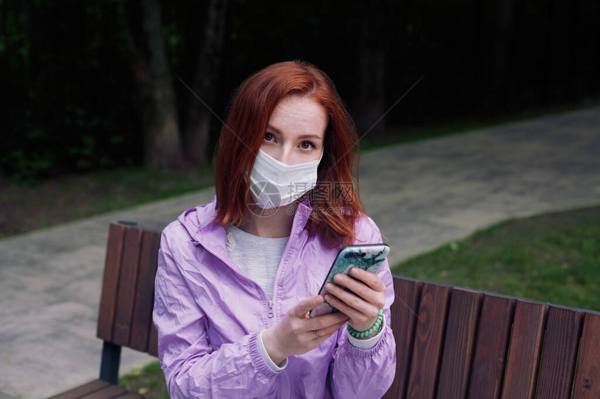 身戴保护面罩的金吉儿女孩坐在公园里图片