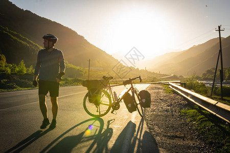 骑自行车的人在休息时间享受路上的山脉全景健康的生活方式和自行车旅图片