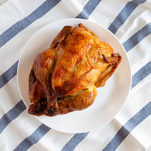 白盘子上的自制传统烤鸡俯视平躺顶图片
