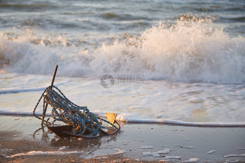 旧船锚在海浪背景上在太阳的图片