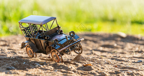 自制金属模型一辆旧复古汽车的玩具在沙路上行驶并撞到石头上汽车停图片