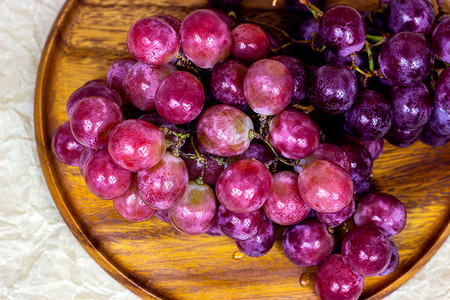 新鲜多汁粉红色和紫色葡萄莓的顶端景象在木图片