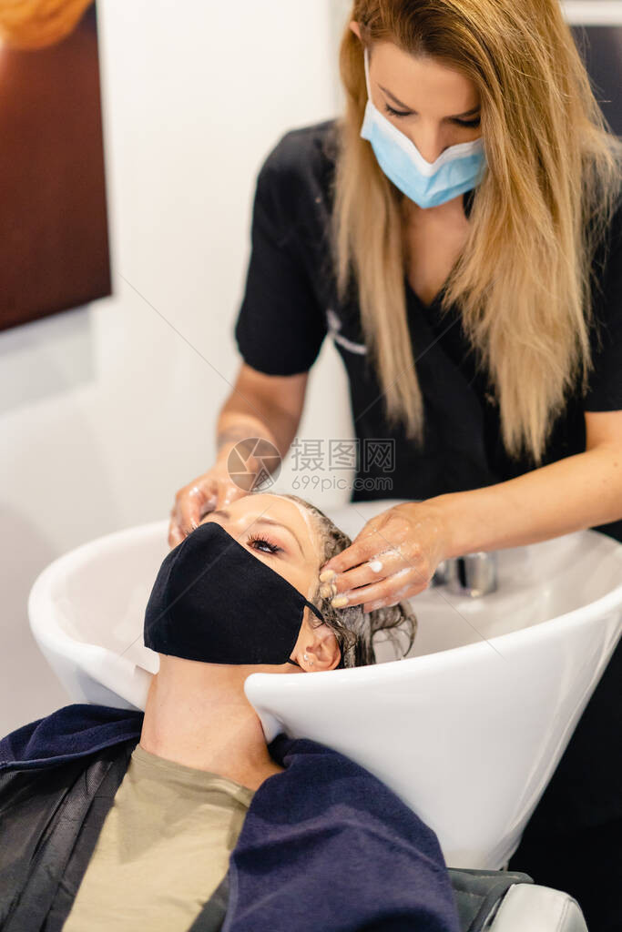 女理发师在一家沙龙洗客户头的女理发师图片