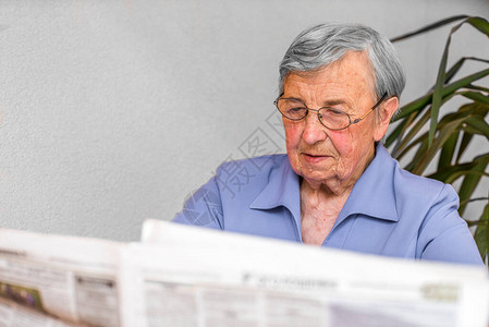 戴眼镜灰色头发的老祖母读了一本图片