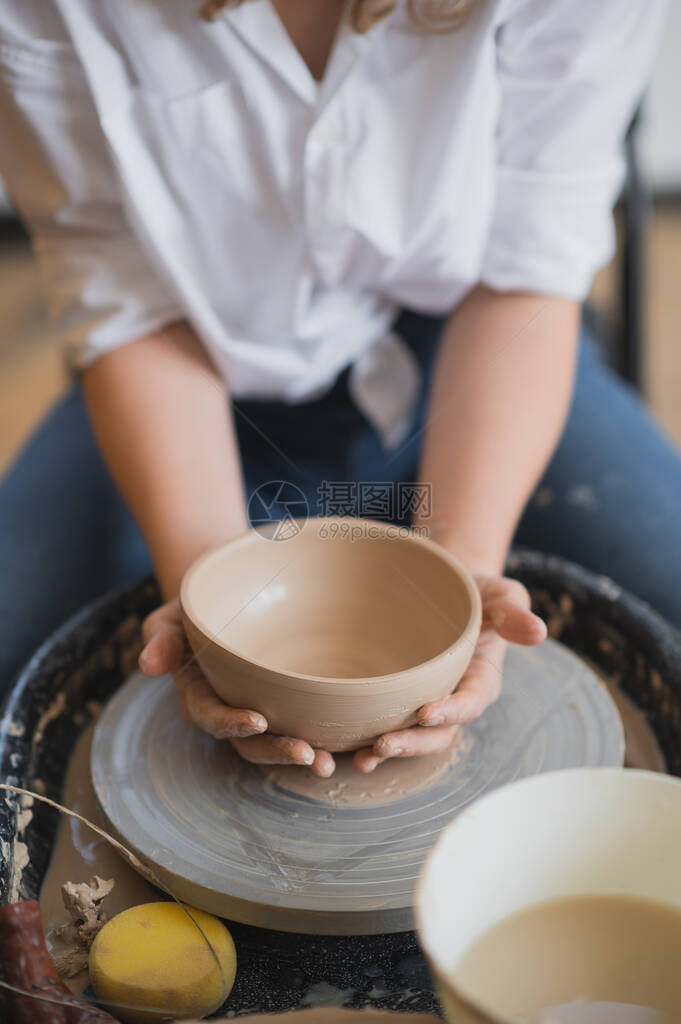 女陶工完成了一个粘土花瓶的制作图片