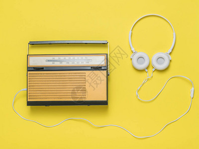 黄色背景的有复古收音机的耳机电台实况广图片