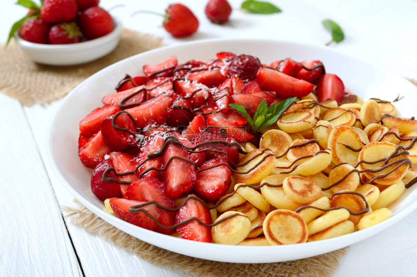 鲜草莓和坚果放在白色木质背景上图片