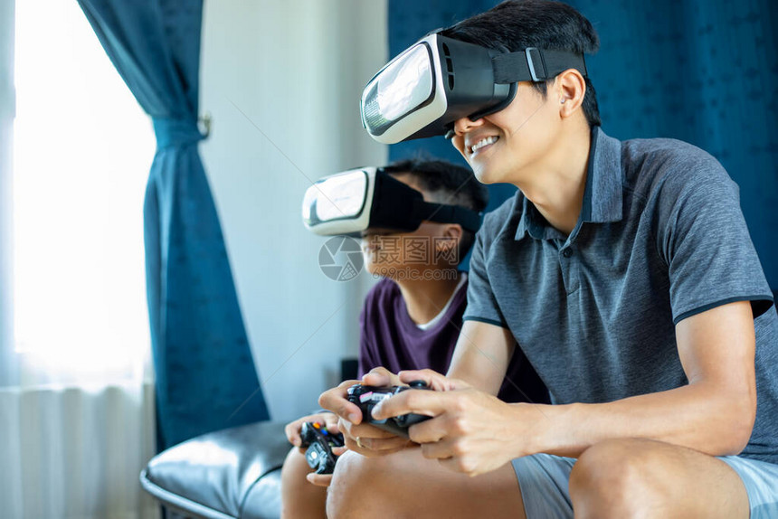 亚洲父子喜欢在家里的客厅里玩视频游戏图片