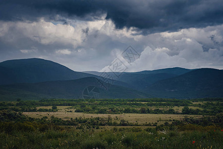 雷雨前山间风景如画的绿色山谷图片