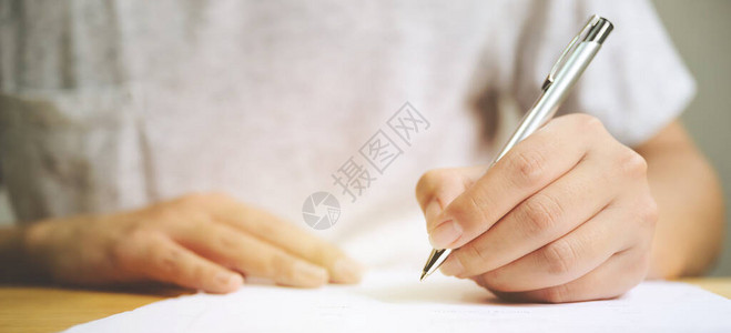 男子手在填写申请表格中签字的签字上签字的人手商业图片
