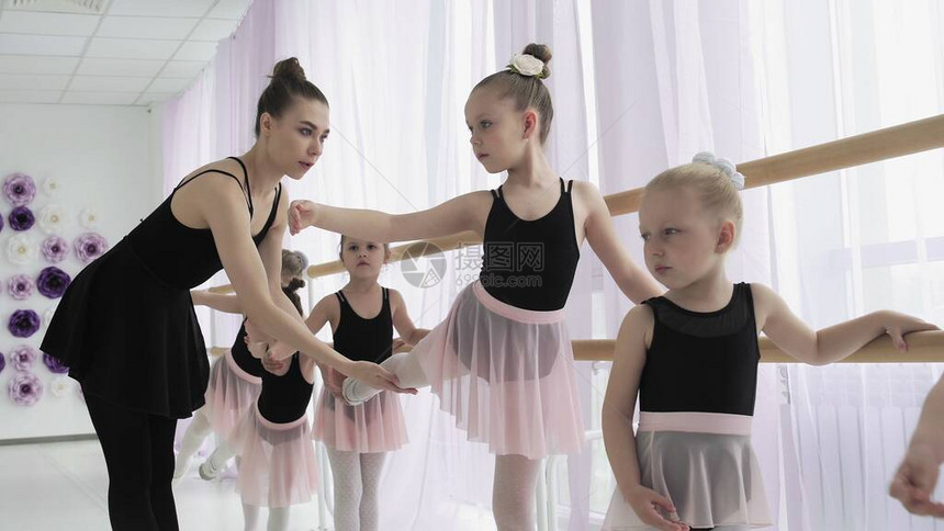 教师向小芭蕾舞演员展示如何跳舞芭蕾舞学校的女舞者学习跳舞年轻的芭蕾舞演员在训练中跳跃芭蕾图片