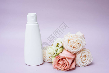 粉红色背景的玫瑰花旁的白色管子中湿润体图片