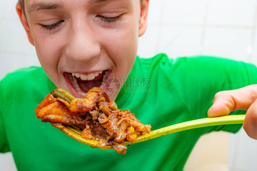 青少年热切地吃脂肪油炸肉把垃圾食品结图片