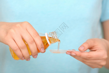 女人从瓶子里倒止咳糖浆特写高清图片
