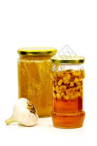 玻璃罐中蜂蜜和大蒜的自制药品图片