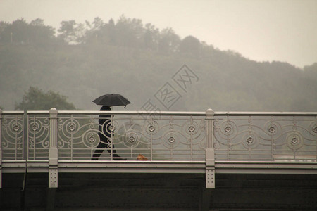 雨中撑伞行走图片