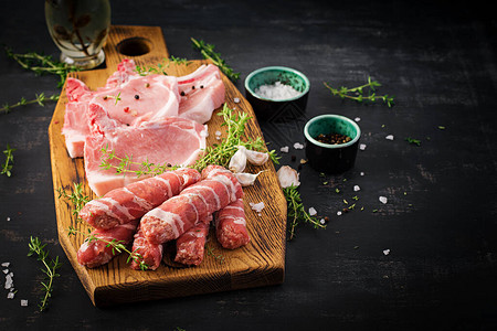 原猪肉牛排不同种类的生猪肉和黑桌图片