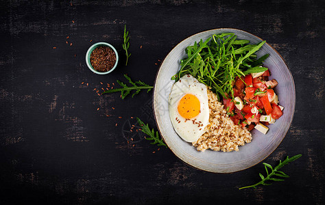 早餐燕麦粥加炸鸡蛋番茄沙拉黄油和麻籽健康平衡的食物顶端视图顶图片