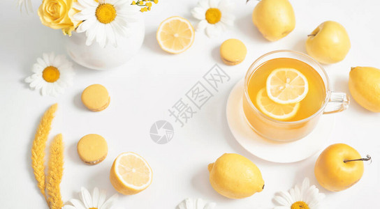 春夏卡带柠檬片的雏菊茶杯与鲜花洋甘菊在杯子里的凉茶维生素图片