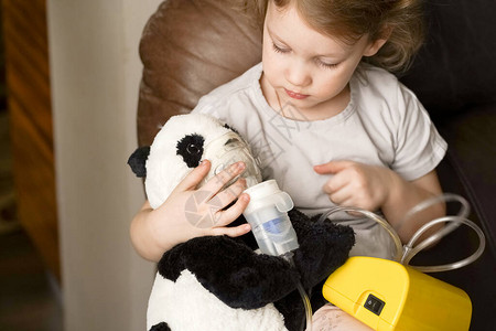 女孩在家中吸入喷雾器熊猫玩具图片