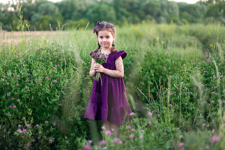 一个穿紫色裙子的小女孩站在一朵鲜花里图片