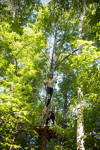 女人和男人在绿林里玩绳子娱乐站在高处图片