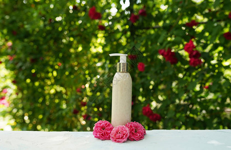 化妆瓶和天然的洗身液用粉红色花束图片