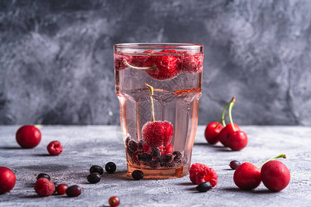 在石混凝土背景上用红面玻璃杯夏季饮食料角视等新鲜的冰冷汽水背景图片