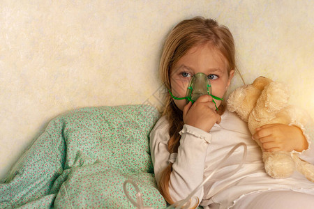小女孩在家里的床上用雾化器吸入生病的过敏儿童哮喘吸入器蒸汽咳嗽儿童过敏概念呼吸系统疾病肺部药物治疗季图片