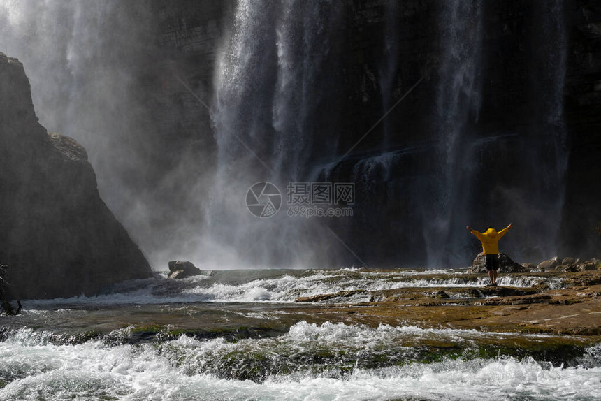 穿着黄色夹克的游客在土耳其的Tortum瀑布放松在土耳其埃尔祖鲁姆的托尔图姆瀑布图片