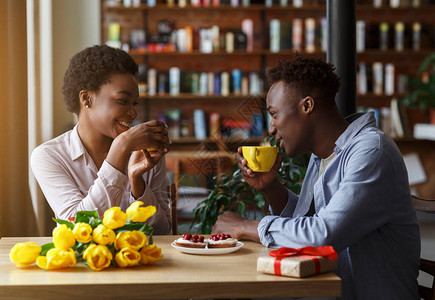 浪漫的节日庆典可爱的非裔美国人夫妇与礼物盒和鲜花一起在市图片