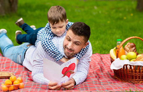 父亲节庆祝爸在公园野餐时读儿子贺图片