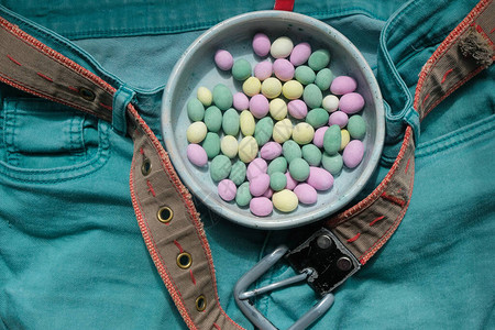 水薄荷牛仔裤有一个带有小糖果的陶瓷盘子与牛仔裤同色的糖果甜蜜的生活理背景图片